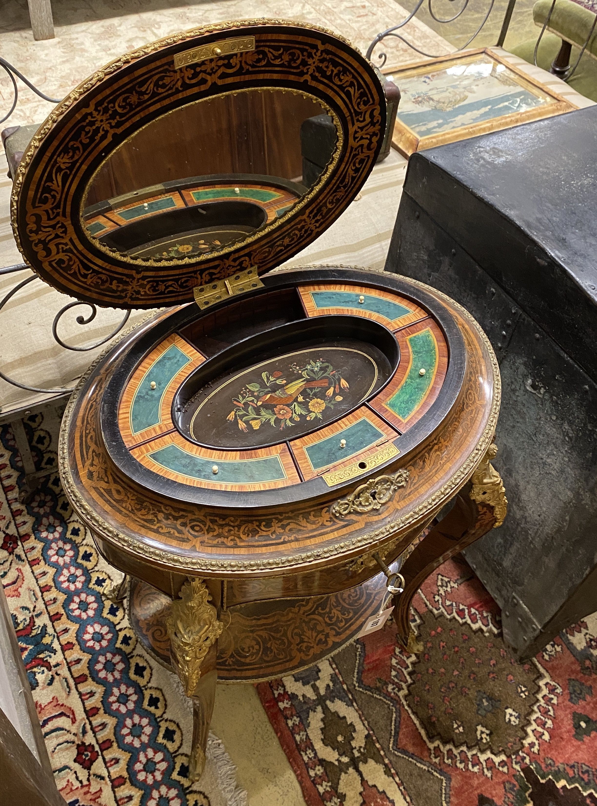 A Louis XVI style marquetry inlaid oval gilt metal mounted two tier work table, width 56cm, depth 42cm, height 78cm